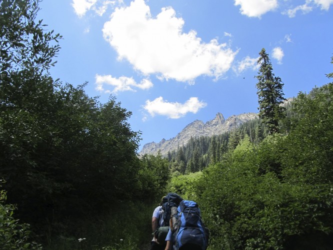 Campers with backpacks hike on a trail in the Trinity Alps