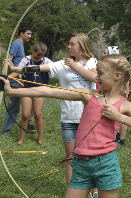 Two girls about to loose arrows from bows