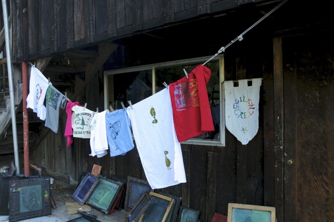 Silk screened shirts hang to dry out side the silk screening studio