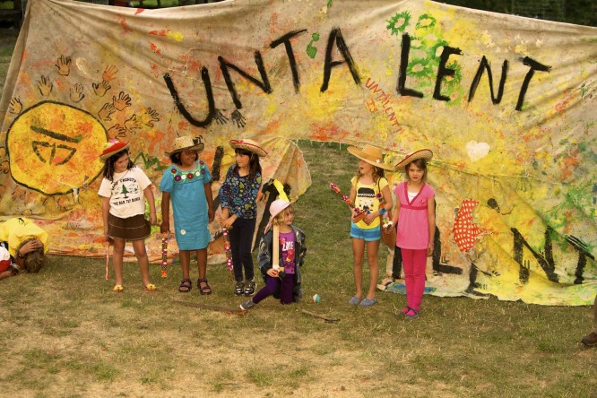 Campers perform a skit in front of the Untalent Show banner