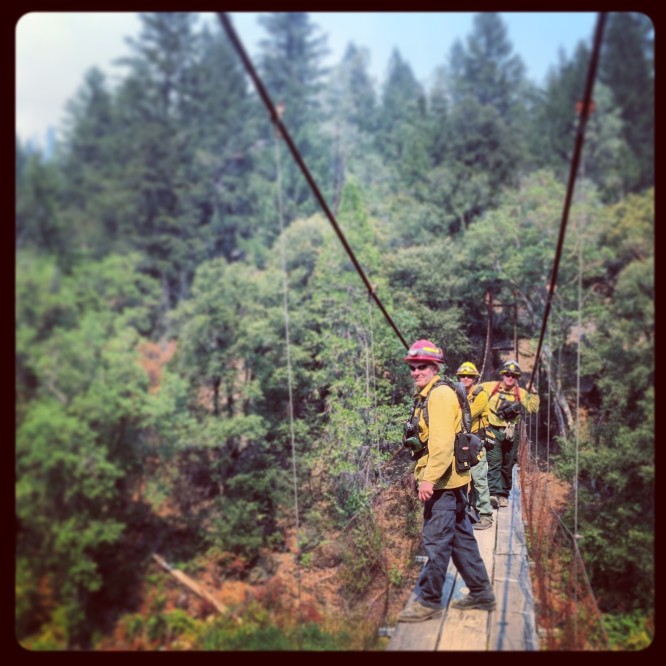 Firefighters on the Bar 717 Ranch suspension bridge at the Pattison Fire - Part of the South Complex